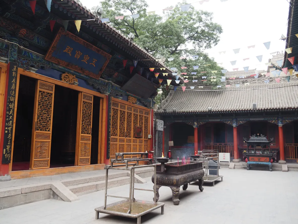 Courtyard and halls of the White Cloud Temple in Beijing, with incense burners and tiled roofs.