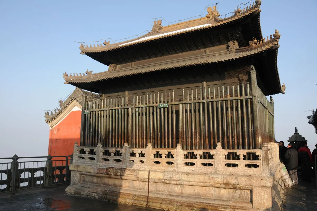 Temple buildings on the Wudang mountains, tiled roofs rising out of forested ridges in mist.